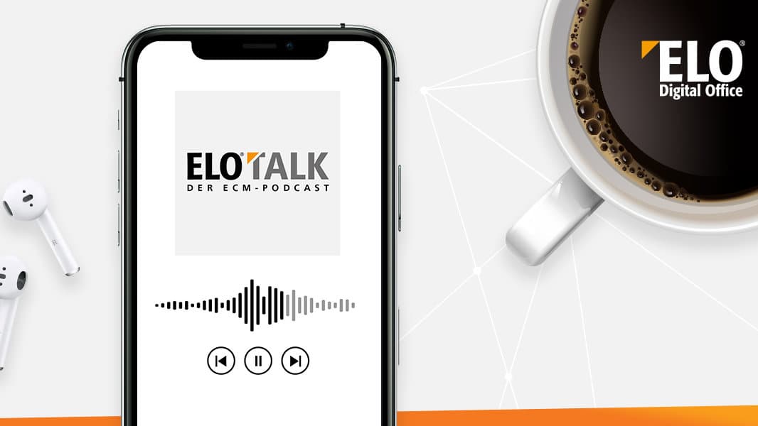 Handy worauf der ElOtalk Podcast abgespielt wird und eine Tasse Kaffee