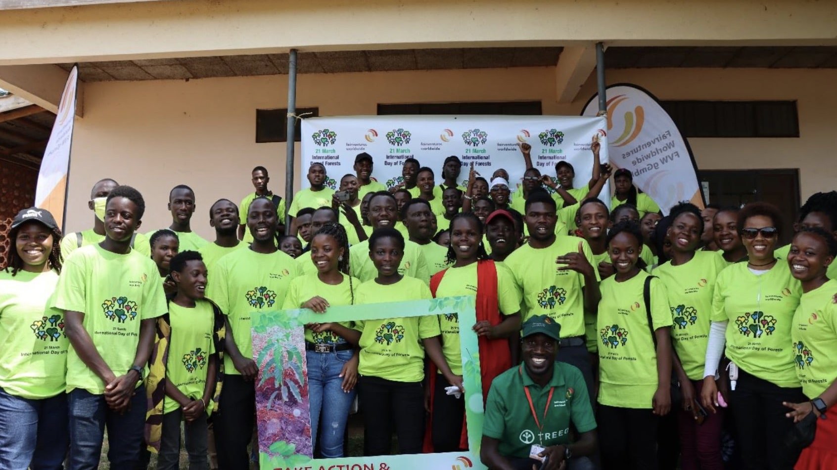 young group of people in neon yellow project t-shirts pose on international forest day