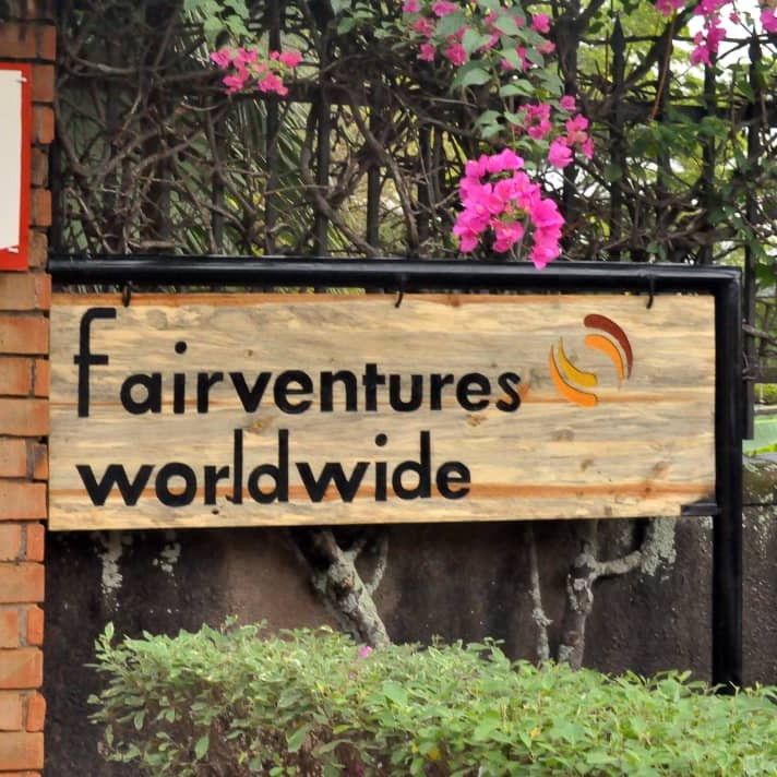 Wooden sign Fairventures Worldwide in front of the office in Uganda